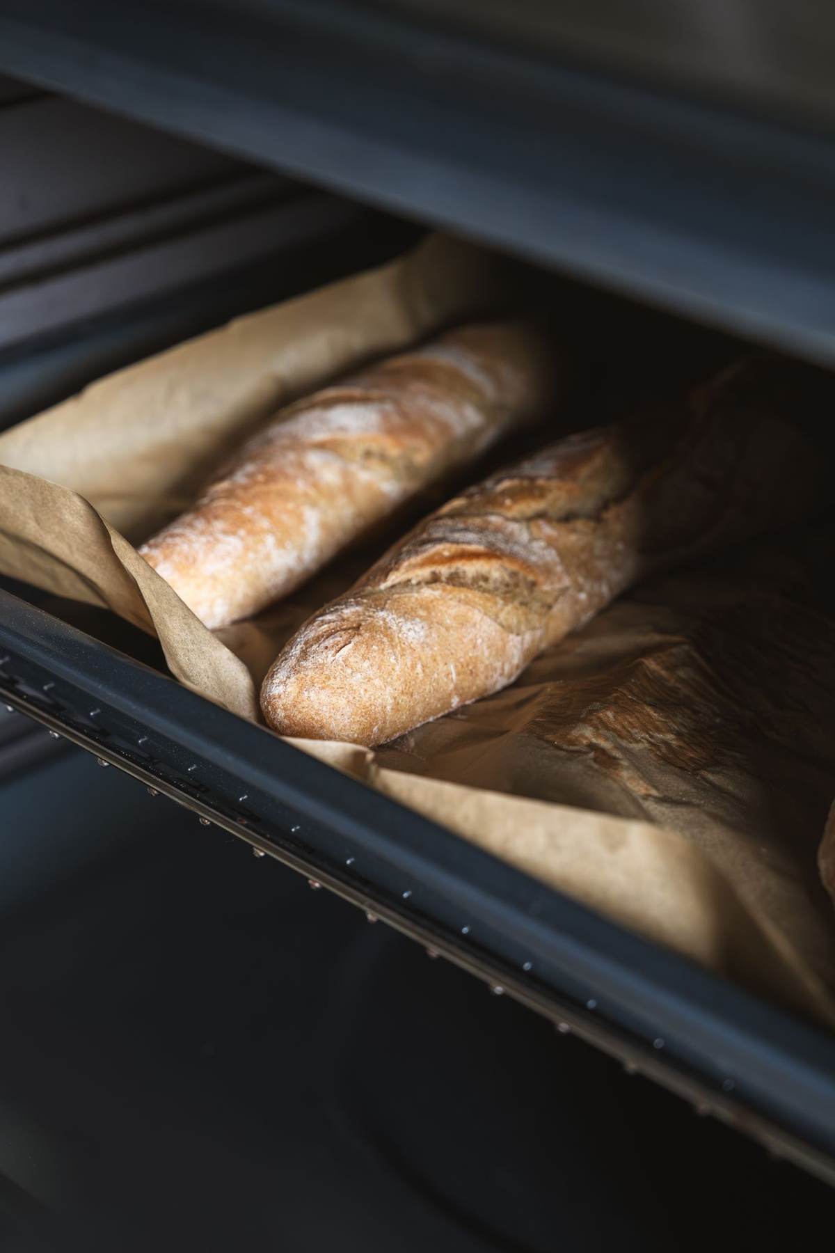 To lange brød står i en ovn set i smalt udsnit