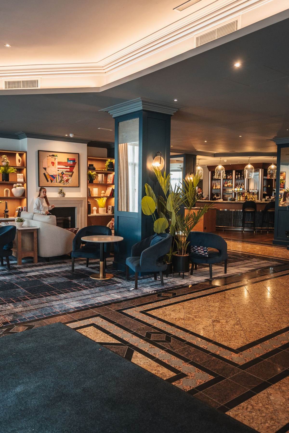 Hotellounge med sofagrupper og et mønstret gulv