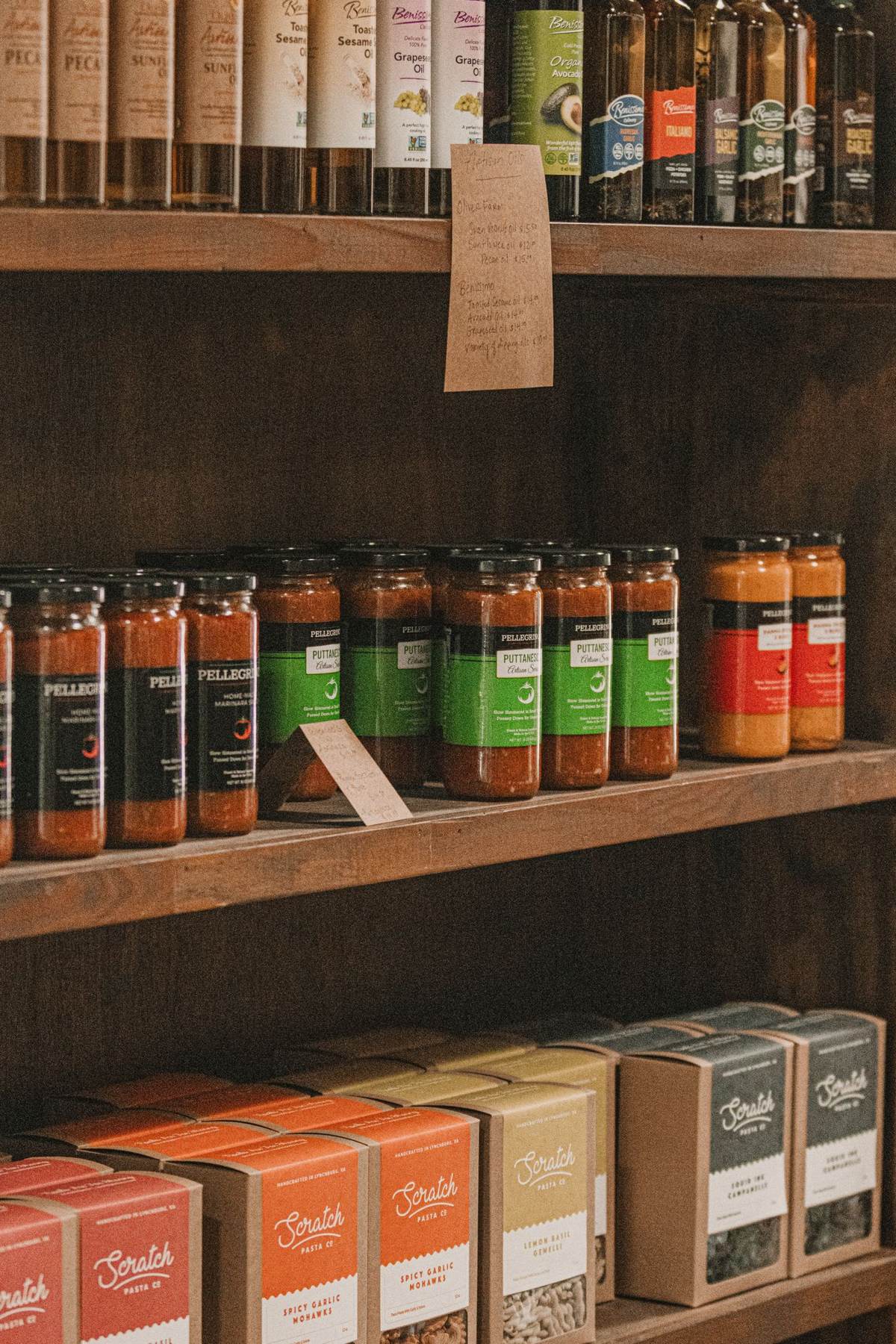 Hylder af træ med flasker og krukker med lokale produkter
