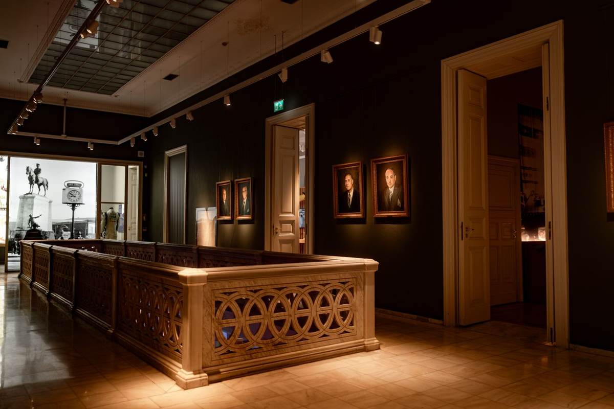 Dunkelt galleri med en lysende skranke og malerier på væggene