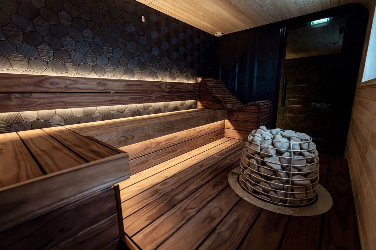 Sauna med trappeformede bænke, ovn og lysliste