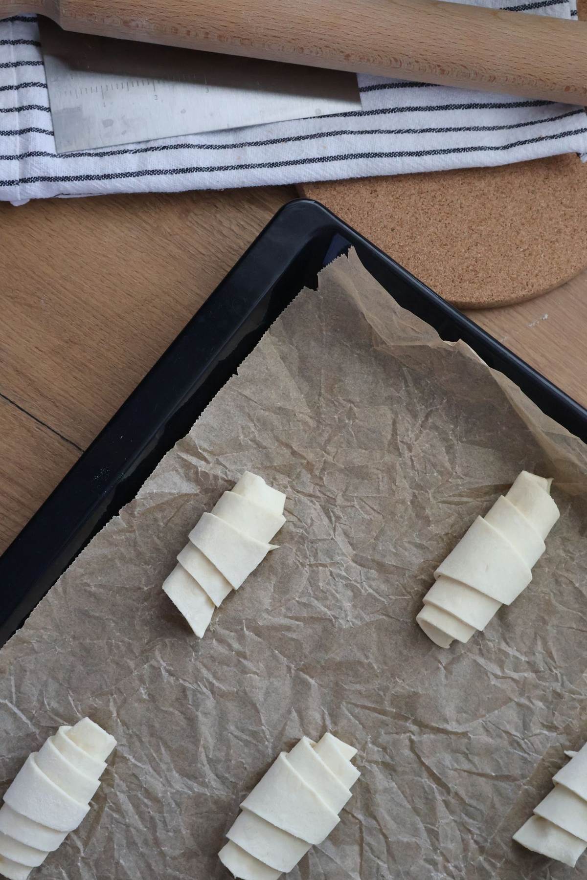 Rullede croissantdeje på en plade med bagepapir