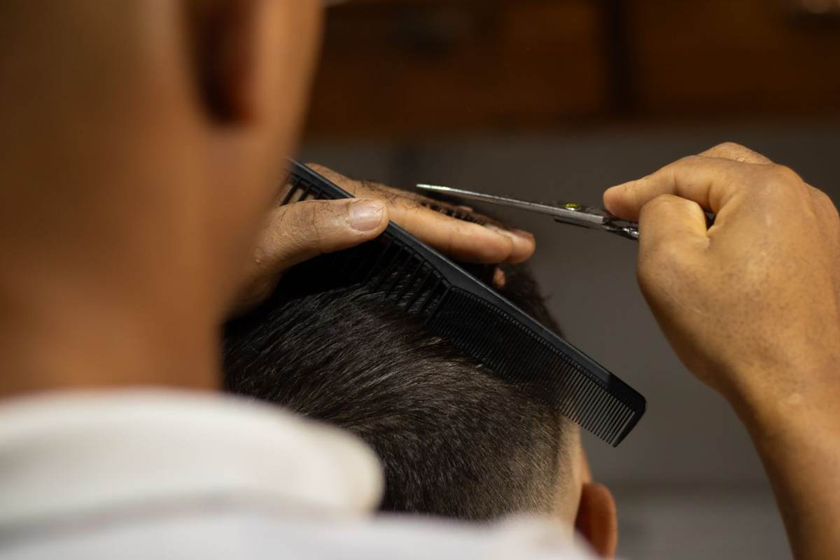 Barber klipper en mands hår bagfra