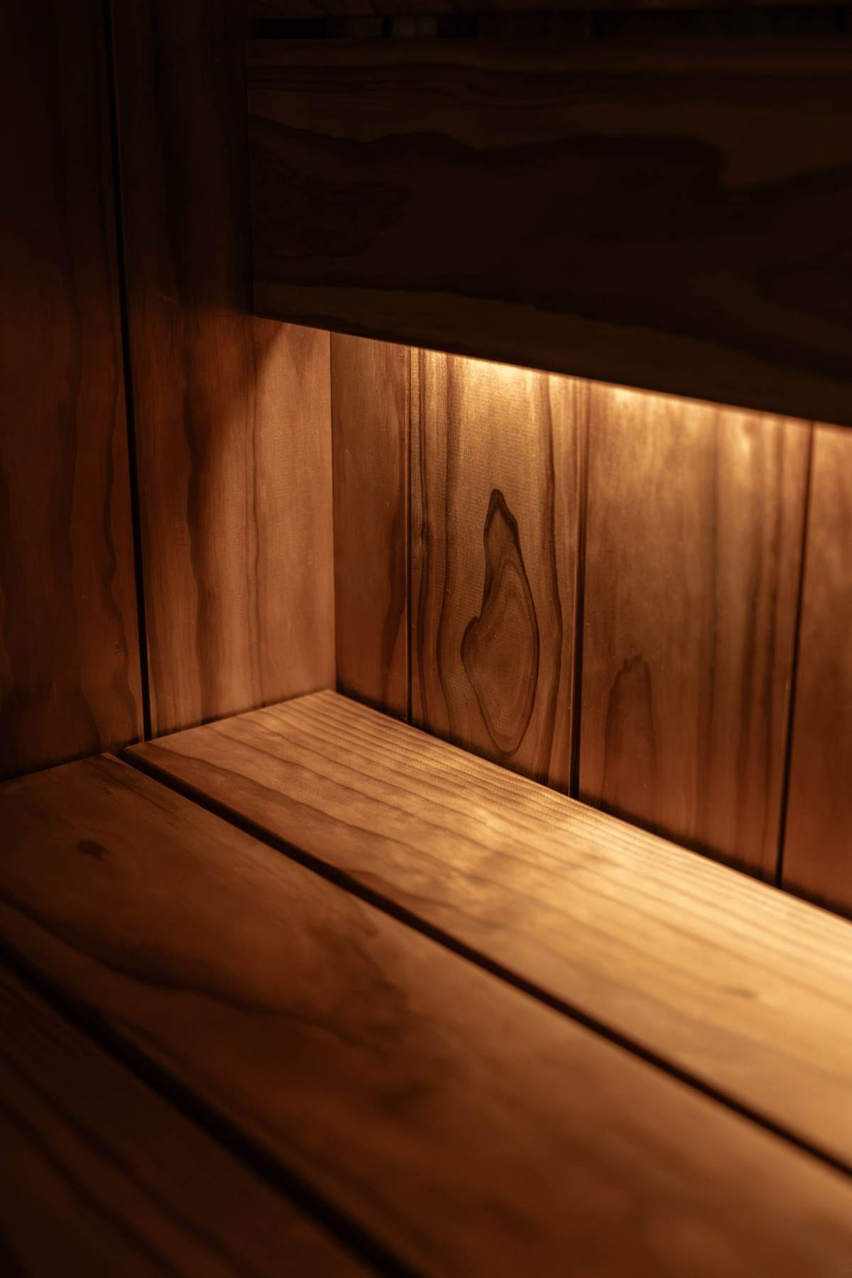 Varmt lys langs en træbænk i en sauna