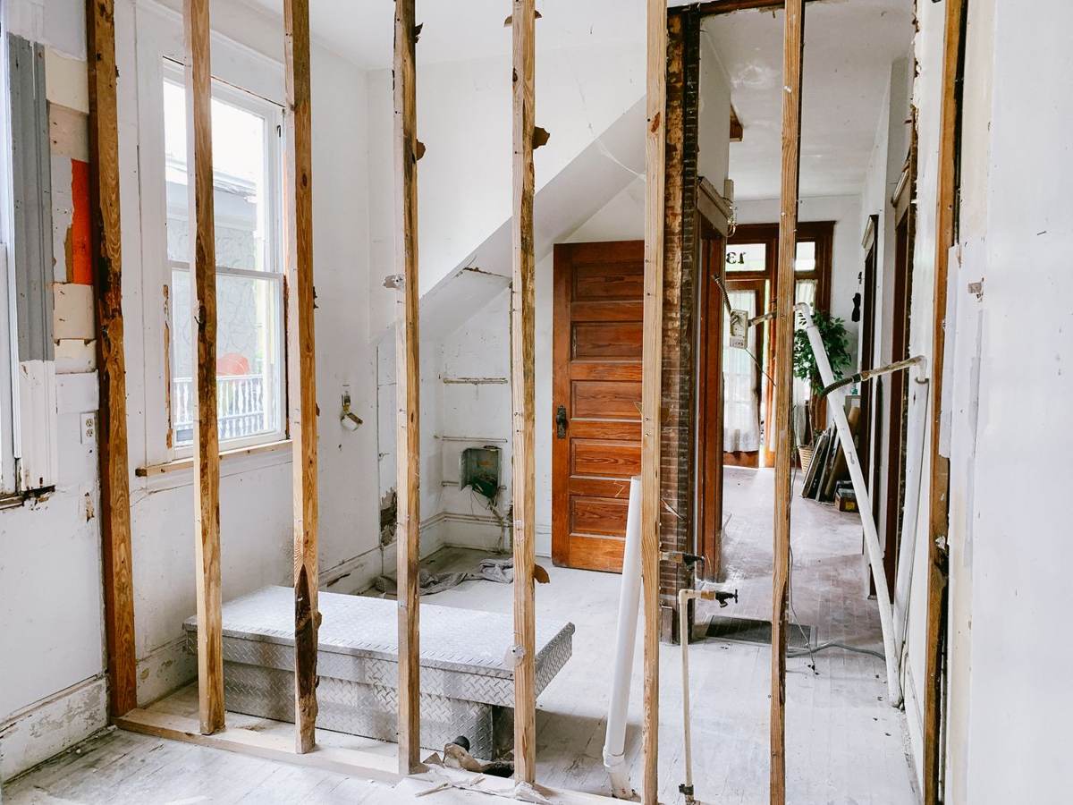 Et rum under renovering med blottede stolper og et vindue
