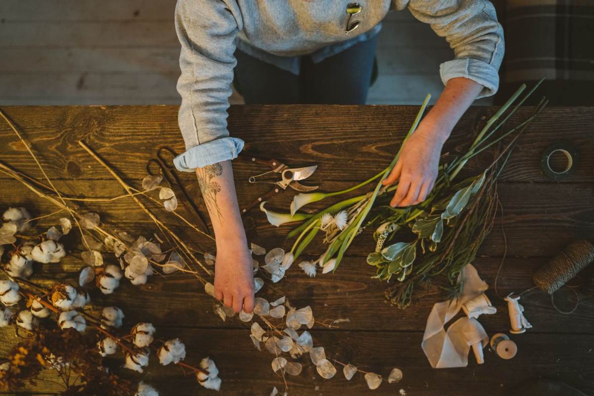 Tørrede og friske blomster sorteret på et mørkt træbord