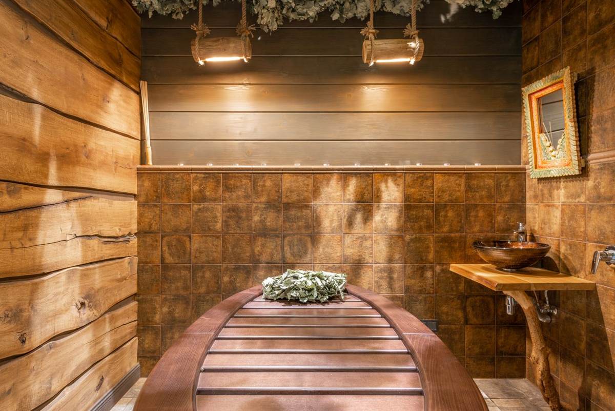 Rustik sauna med træpaneler, en bænk og et lille billede på væggen